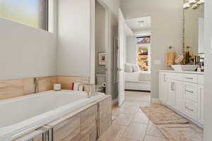 Full bathroom featuring a bath, vanity, and ensuite bath