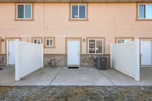 Rear view of property featuring a patio, brick siding, and stucco siding