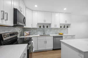Kitchen with stainless steel appliances, open shelves, NEW white soft close cabinetry, NEW Quartz countertops, and NEW recessed lighting