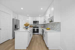 Kitchen featuring NEW white soft close cabinetry, stainless steel appliances, a NEW kitchen island, NEW recessed lighting, and NEW Quartz countertops