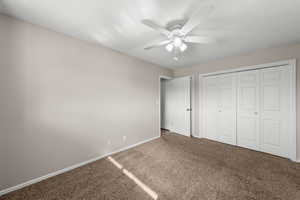 Unfurnished bedroom featuring carpet floors, a closet, and a ceiling fan