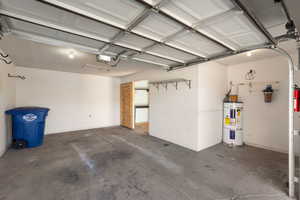 Garage featuring strapped water heater and a garage door opener