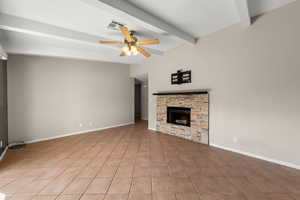 Unfurnished living room featuring ceiling fan, a fireplace, beam ceiling, and light tile patterned floors