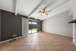 Unfurnished room featuring ceiling fan, vaulted ceiling with beams, and light tile patterned floors