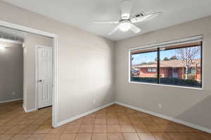 Empty room featuring a ceiling fan and baseboards
