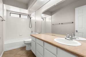 Bathroom featuring vanity, bathing tub / shower combination, and light tile patterned flooring
