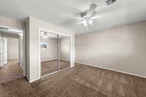 Unfurnished bedroom with carpet flooring, a closet, ceiling fan, and a textured ceiling