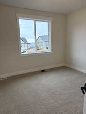 Spare room with light colored carpet and baseboards