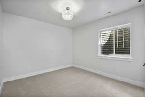 Spare room with carpet and baseboards
