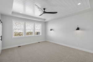 Carpeted empty room featuring ceiling fan, a wooden tray ceiling, and recessed lighting