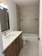 Bathroom with vanity, shower / washtub combination, and a textured ceiling