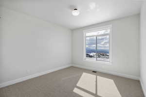 Unfurnished room featuring light colored carpet and a mountain view