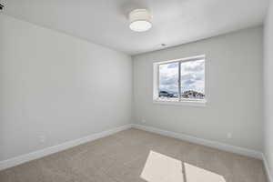 Unfurnished room featuring light colored carpet and baseboards