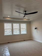 Spare room featuring light carpet, ceiling fan, a wood tray ceiling, and recessed lighting