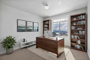 Office space with light colored carpet and baseboards