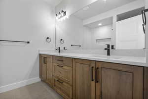 Full bath with double vanity and light tile patterned flooring