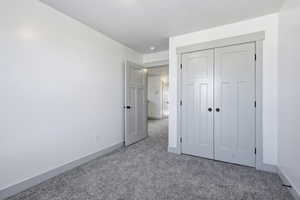 Unfurnished bedroom featuring carpet flooring and a closet