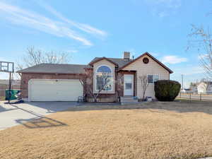 Ranch-style home featuring concrete driveway, a garage, brick siding, and a shingled roof