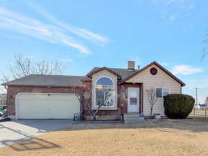 Ranch-style home featuring concrete driveway, a garage, brick siding, and a shingled roof