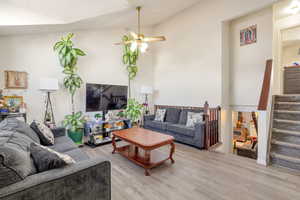 Living area featuring wood finished floors, ceiling fan, and a high ceiling
