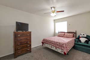 Bedroom with a textured ceiling, a ceiling fan, and carpet flooring