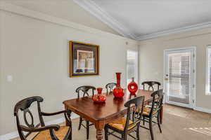 Dining area featuring lofted ceiling and baseboards