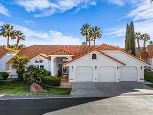 Mediterranean / spanish-style home with a tiled roof, stucco siding, driveway, and an attached garage