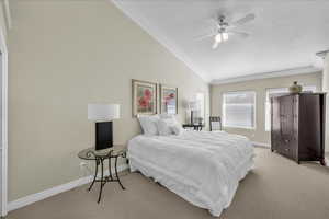 Bedroom featuring lofted ceiling, carpet floors, ceiling fan, and ornamental molding