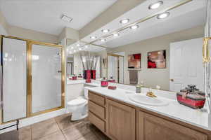 Full bathroom featuring a stall shower, vanity, light tile patterned floors, and recessed lighting