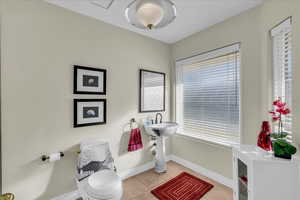 Half bath with toilet and light tile patterned floors