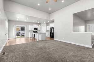 Unfurnished living room with light colored carpet, ceiling fan, and recessed lighting