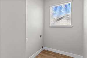 Laundry room with hookup for an electric dryer and light wood-style floors