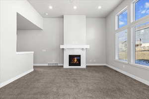 Unfurnished living room with a brick fireplace, carpet, and recessed lighting