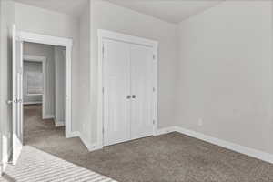 Unfurnished bedroom featuring carpet and a closet