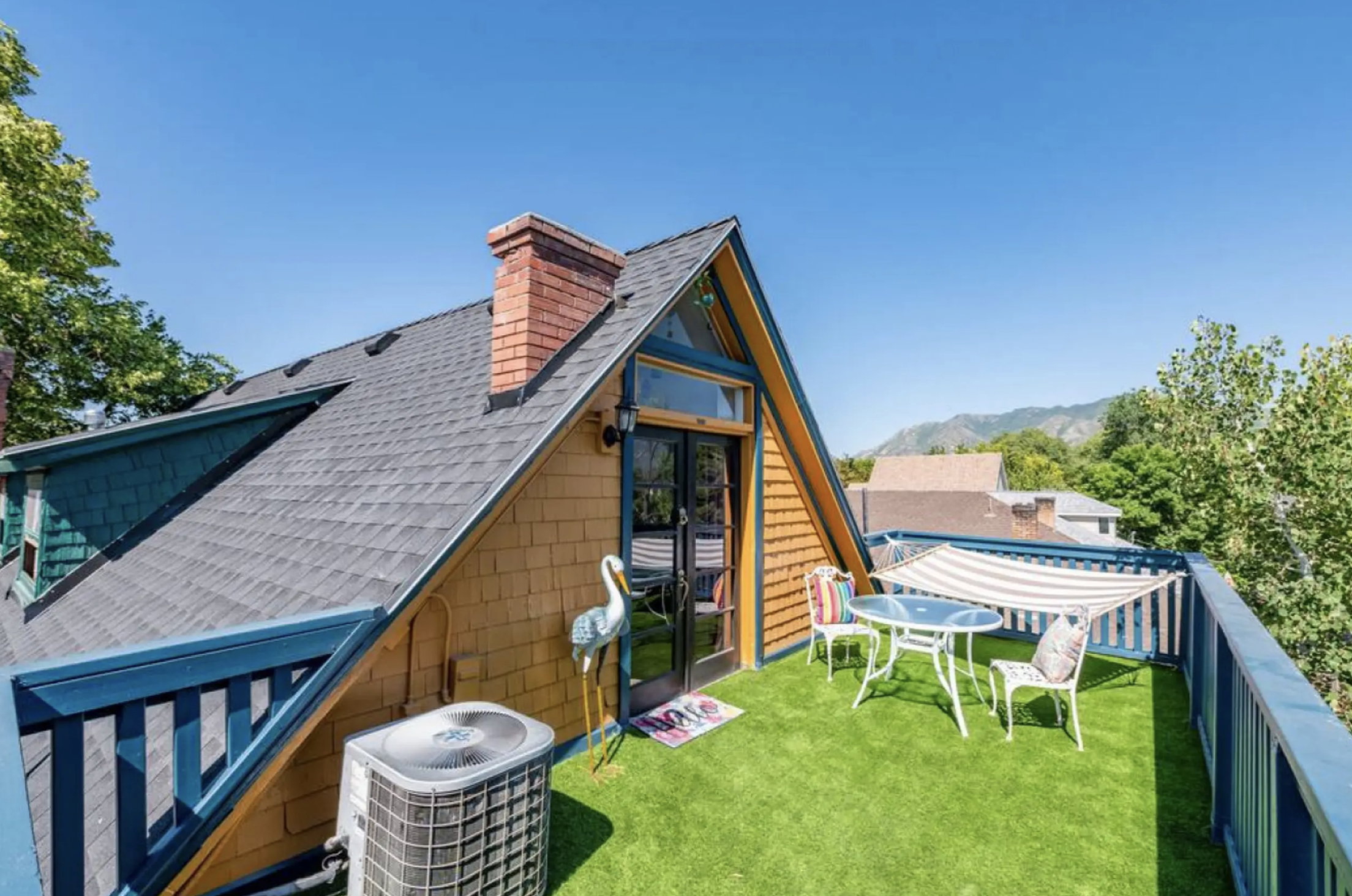 Back of property featuring roof with shingles, a chimney, french doors, and a lawn