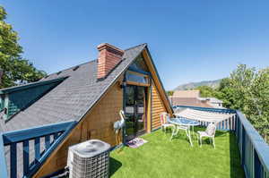 Back of property featuring roof with shingles, a chimney, french doors, and a lawn