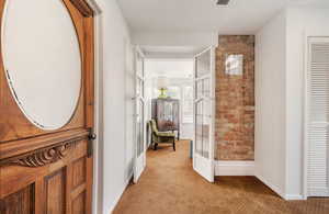 Hallway with light carpet and baseboards