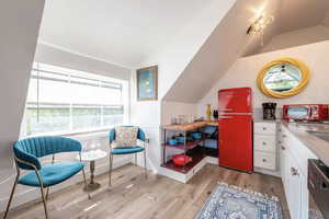Sitting room featuring light wood-style floors and lofted ceiling