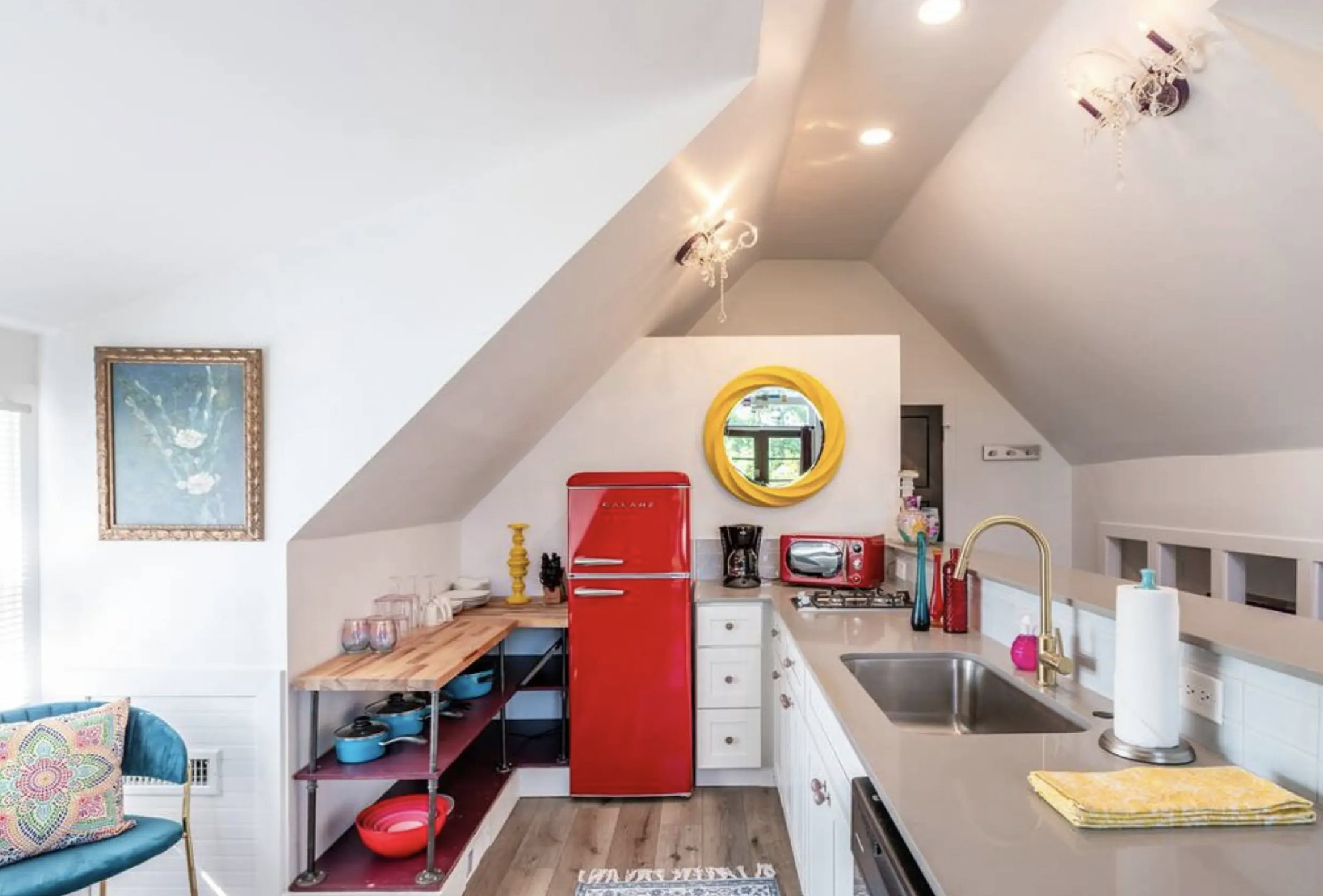 Kitchen featuring freestanding refrigerator, white cabinets, lofted ceiling, light wood finished floors, and stainless steel dishwasher