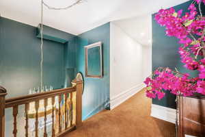 Hallway featuring baseboards and carpet