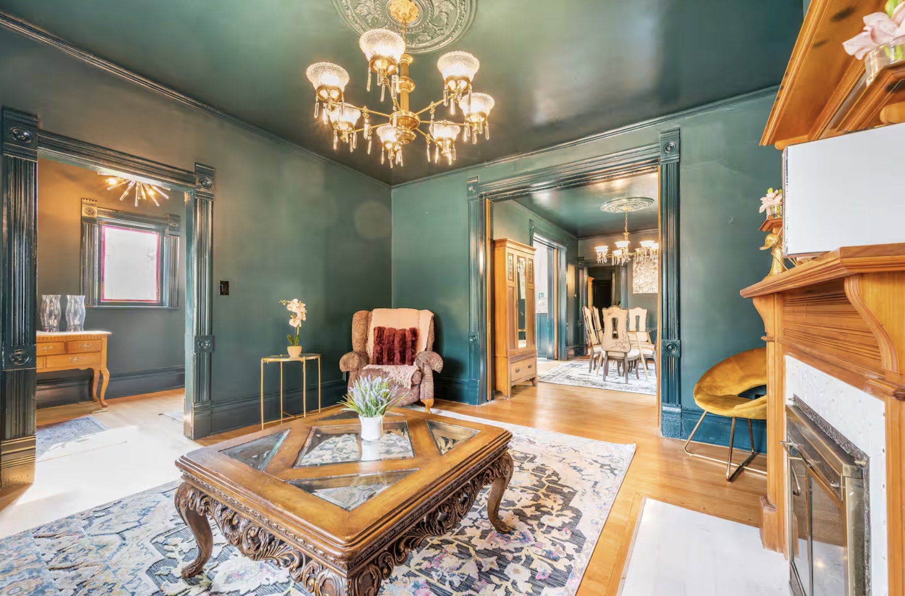 Sitting room with a chandelier, wood finished floors, a fireplace with flush hearth, and ornamental molding