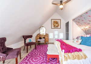 Bedroom with vaulted ceiling, a closet, ceiling fan, and wood finished floors