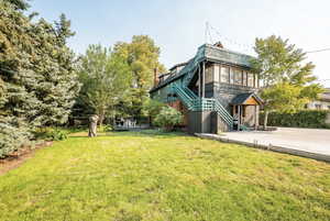 Back of house featuring stairs and a balcony