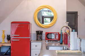 Kitchen view of freestanding refrigerator and white cabinetry