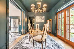 Dining space with ornamental molding, hanging lights, and wood finished floors