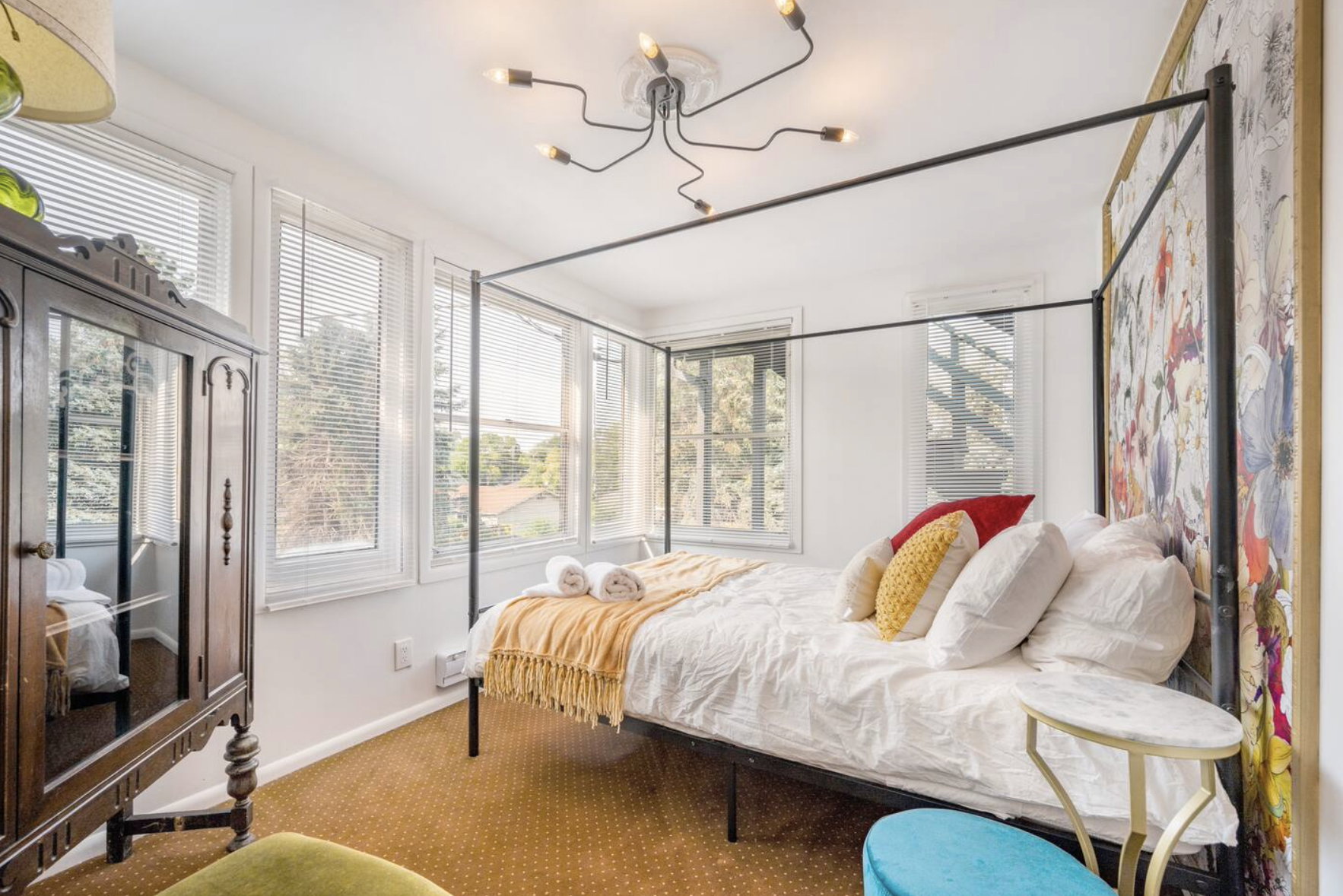 Bedroom featuring carpet, multiple windows, and hanging lights