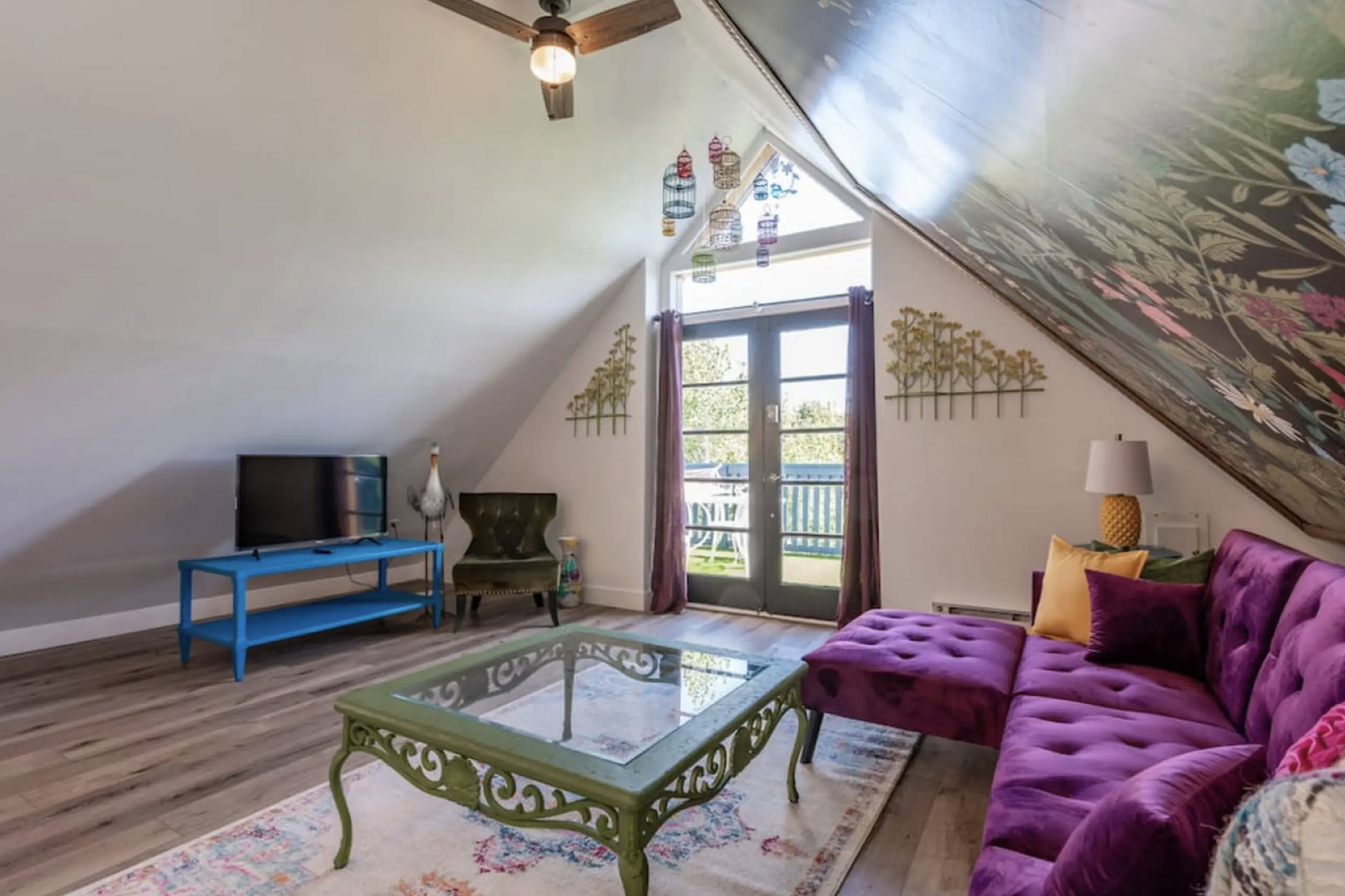 Living room with french doors, wood finished floors, and lofted ceiling