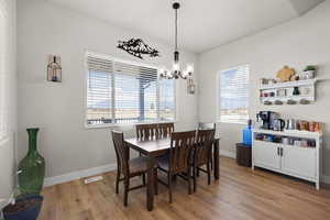 Dining area with light wood finished floors and suspended lighting
