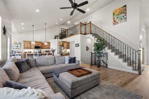 Living area featuring a ceiling fan, light wood-style floors, a high ceiling, and recessed lighting