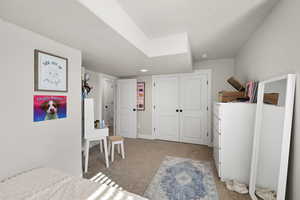 Bedroom featuring light carpet and a closet